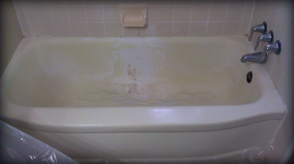 Worn, stained cast-iron bathtub before refinishing